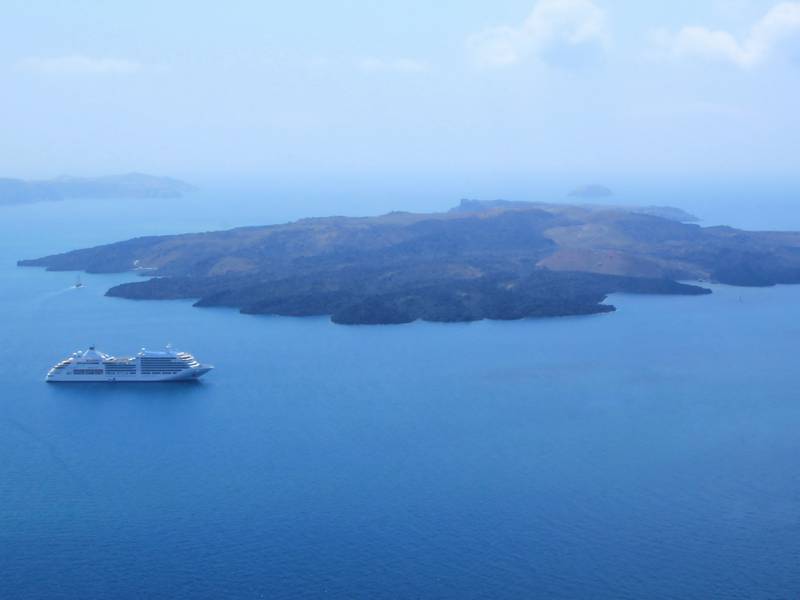 Cruise ships pass by Santorini volcano. Alamy