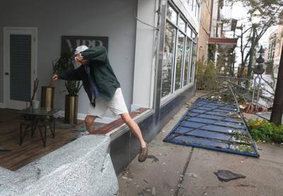 Eddie Elliott climbs through the broken window to his business as Hurricane Sally passes through the area in Mobile, Alabama. AFP