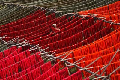 An Indian worker hangs dyed yarn under the sun at a textile mill in Mangalagiri, in the southern state of Andhra Pradesh, India. EPA