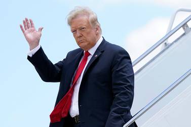 President Donald Trump waves as he arrives on Air Force One at Austin Straubel International Airport in Green Bay, Wisconsin. Iran issued an arrest warrant and asked Interpol for help in detaining Mr Trump and dozens of others it blames for the drone strike that killed Qassem Suleimani. AP