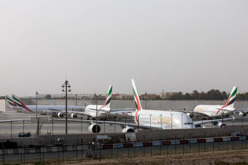 Multiple Airbus SE A380-800 aircraft, operated by Emirates, stand in a parking zone at Dubai International Airport.