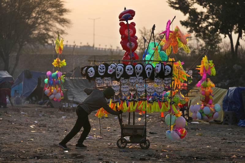 A migrant street vendor pushes his cart to work as he starts his day from his temporary shelter in Jammu, India. AP Photo