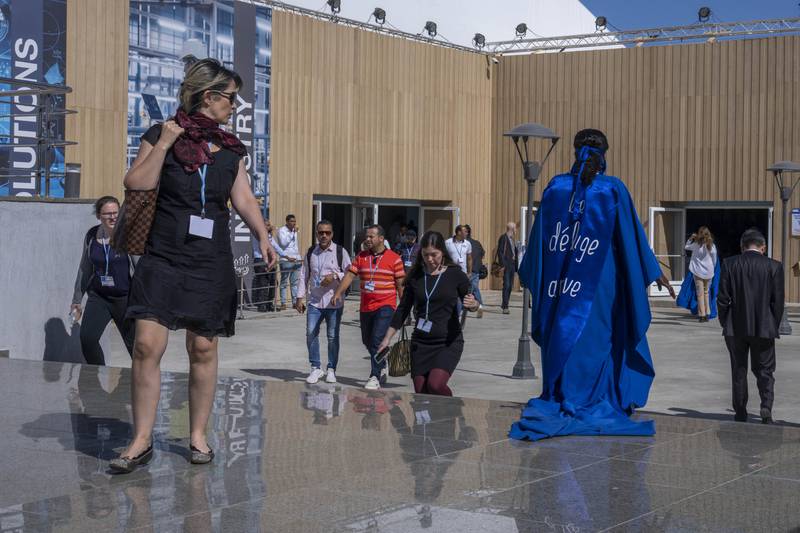'The flood is coming,' reads the head-turning message, in French, on the back of a woman's blue gown. AP Photo