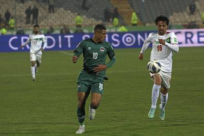 Iran's Omid Nor Afkan, right, and Iraq's Ali Ibrahim Alzubaidi vie for the ball during their 2022 World Cup qualifier at the Azadi Stadium in Tehran.  Iran became the first team from Asia to qualify for this year's World Cup. AP