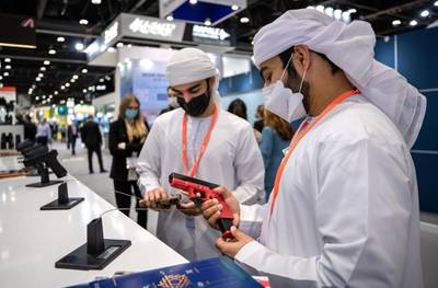 Abu Dhabi, United Arab Emirates, February 21, 2021.  Idex 2021, the first major in-person exhibition held in Abu Dhabi since the start of the Covid-19 pandemic, opened its doors to delegates on Sunday morning.  --Omar Al Matrooshi and Rashed Al Raess looks at a GLOCK 9mm. pistols.Victor Besa / The NationalSection:  NAReporter:  John Dennehy