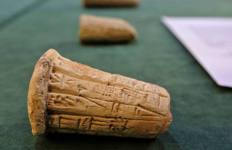 Mesopotamian clay cones bearing cuneiform inscriptions are displayed during the artefact handover ceremony in Baghdad.