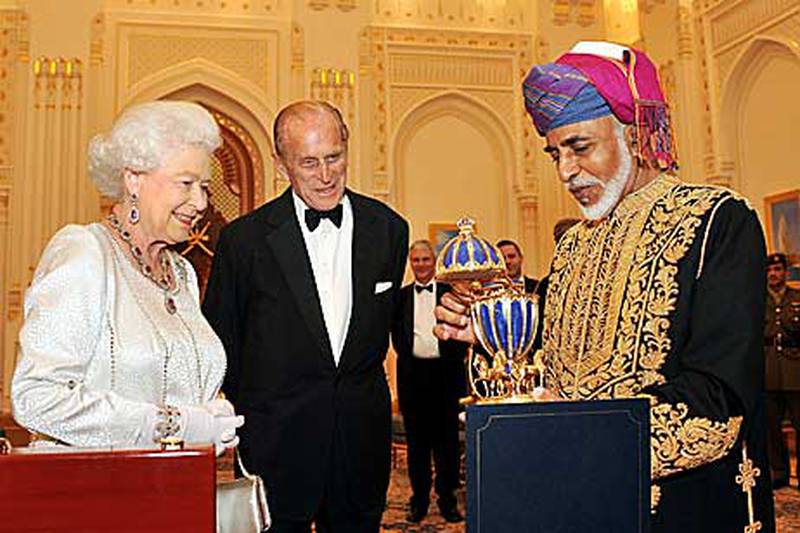 The Sultan of Oman, Sultan Qaboos bin Said, presents Britain’s Queen Elizabeth II with a gold musical Faberge style egg as Prince Philip watches on at the royal palace in Oman.