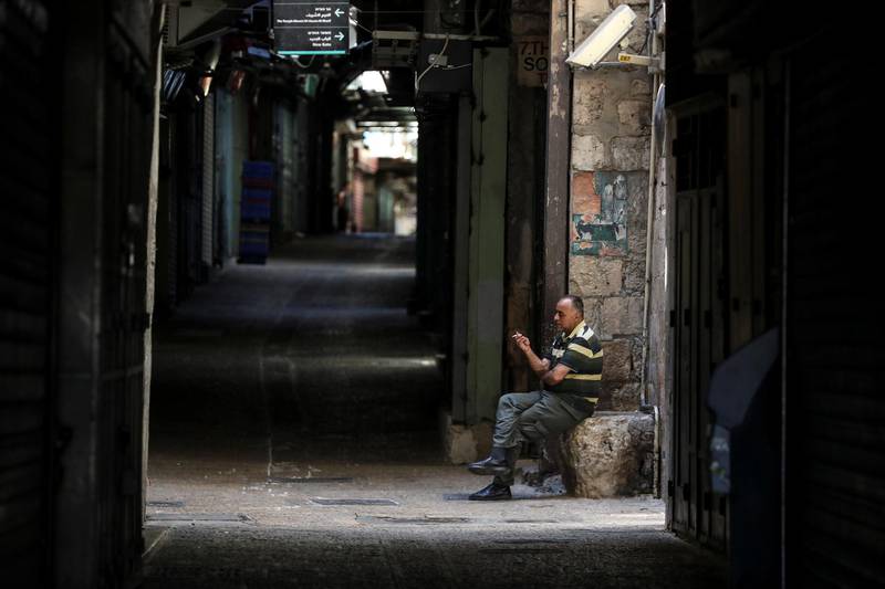 A man smokes near closed shops during a general strike at a market in Jerusalem's Old City. Reuters