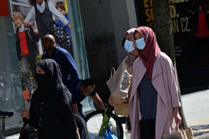 Shoppers wearing protective face coverings walk past shops in Birmingham, central England on August 22, 2020, as Britain's second-city, home to more than one million people, was made an "area of enhanced support", because of concern about a spike in cases of the novel coronavirus. (Photo by JUSTIN TALLIS / AFP)