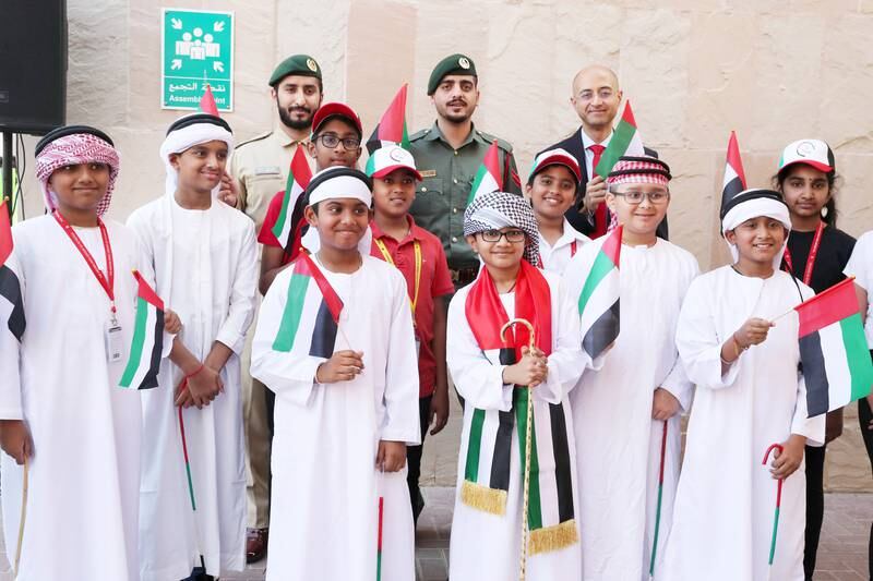 Punit MK Vasu, chief executive of The Indian High Group of Schools with Dubai Police officers and pupils during the UAE Flag Day celebration at the campus in Dubai. Pawan Singh / The National