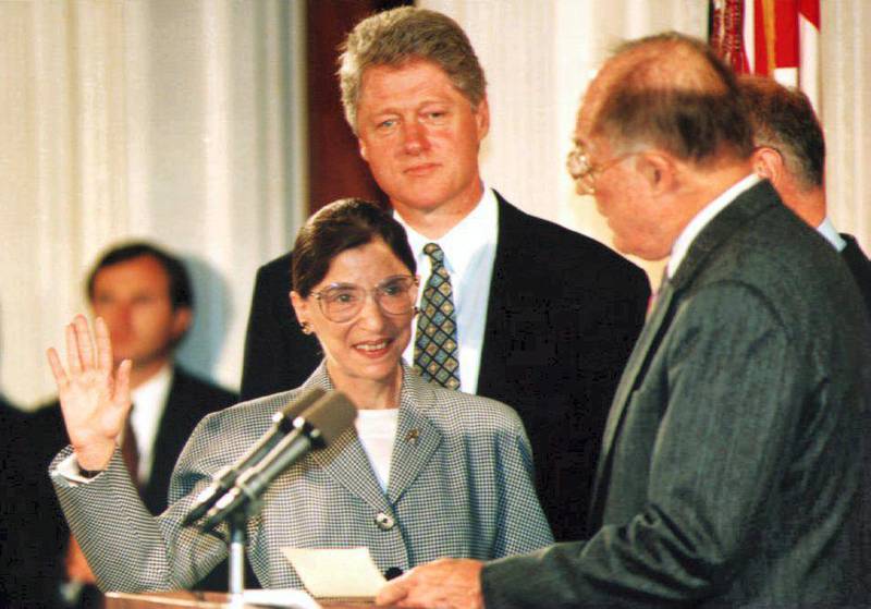Chief Justice of the U.S. Supreme Court William Rehnquist (R) administers the oath of office to newly-appointed U.S. Supreme Court Justice Ruth Bader Ginsburg (L) as U.S. President Bill Clinton looks on 10 August 1993. Ginsburg is the 107th Supreme Court justice and the second woman to serve on the high court. (Photo by KORT DUCE / AFP)