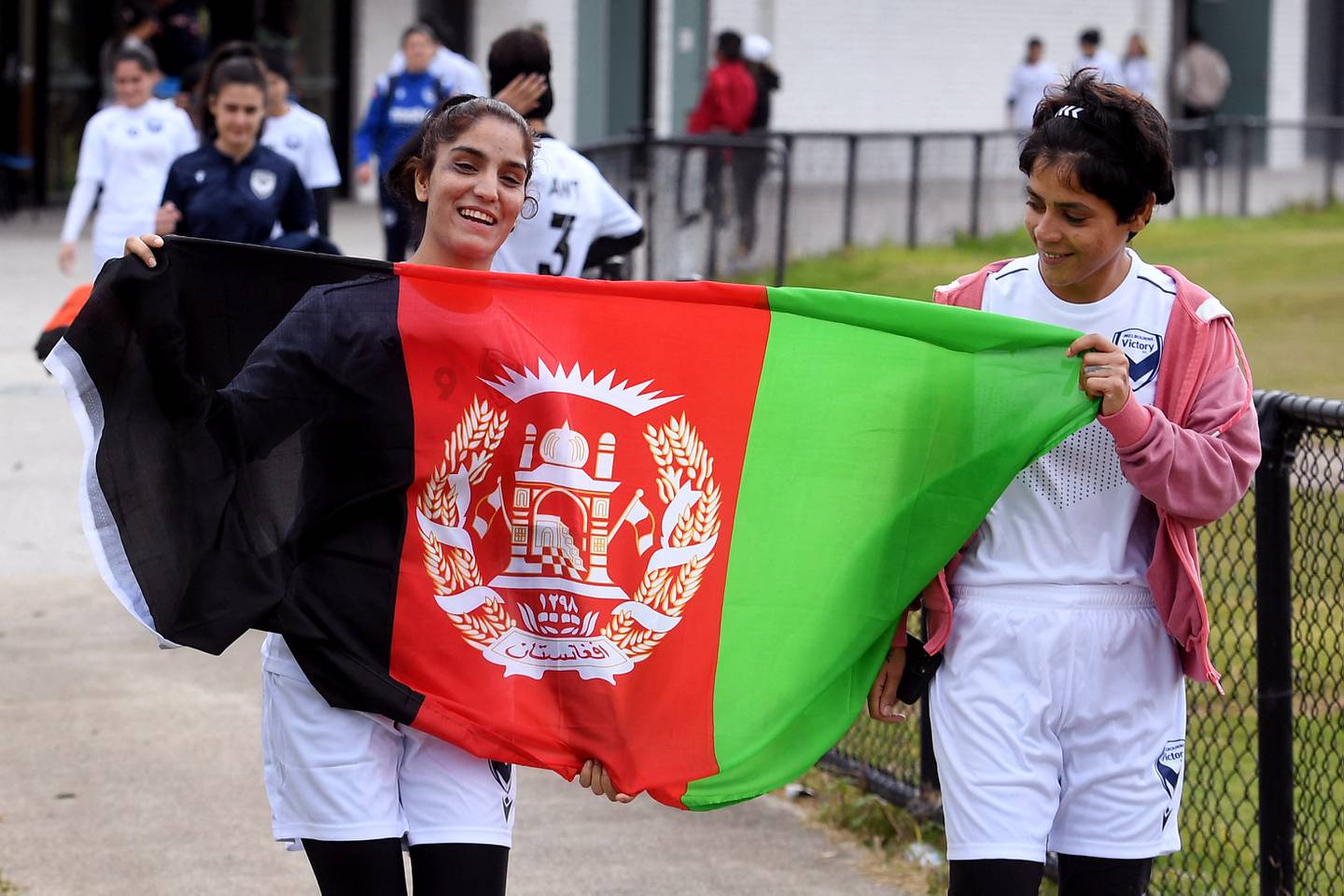 Members of the Melbourne Victory Afghan Women's Team carry the Afghanistan flag before their first match. AFP