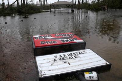 A damaged sign is pictured at a flooded lot during Hurricane Sally in Gulf Shores, Alabama. REUTERS