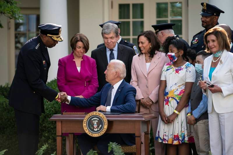 US President Joe Biden shakes hands with Robert Contee III, Chief of the DC Metropolitan Police Department, after signing the bill into law at the White House. EPA