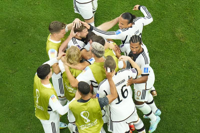 Germany's Niclas Fuellkrug, top centre, celebrates with teammates after scoring his side's first goal. AP