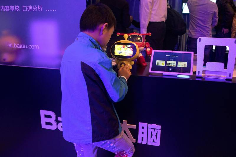 A boy plays a video game in an exhibition area on artificial intelligent (AI) technology at the Baidu World conference in Beijing, China, on Thursday, Nov. 1, 2018. Baidu showcased its artificial intelligence advancements and unveiled new products at the event. Photographer: Giulia Marchi/Bloomberg