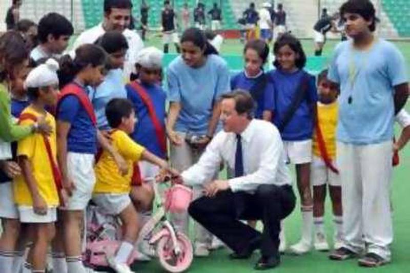 epa02265134 British Prime Minister David Cameron (C) interacts with school children at the national hockey stadium in New Delhi, India, 29 July 2010. Cameron arrived on a two-day maiden visit to India and to deepen his nation's ties with India on using his trip to the former colony turned rising regional power.  EPA/- *** Local Caption ***  02265134.jpg