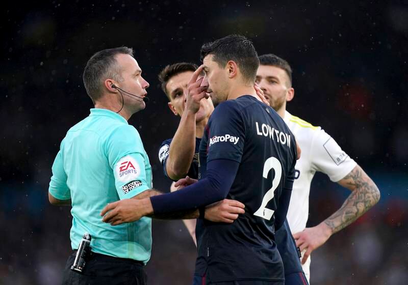 Referee Paul Tierney looks at Burnley's Matthew Lowton after he was hit on the head with a bottle thrown from the stands. AP