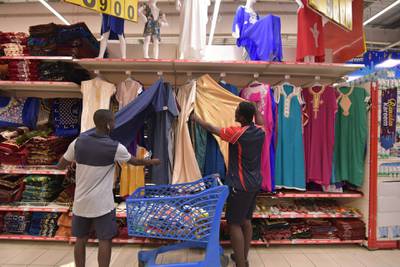 Men look at clothes at the Carrefour supermarket in Abidjan, Ivory Coast.  on the eve of the start of the Ramadan, the Muslim holy month of fasting.  AFP