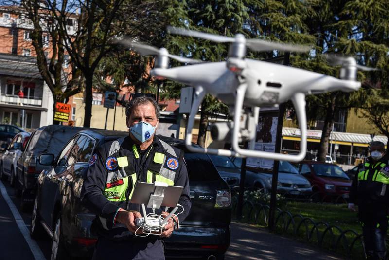 epa08319147 A drone pilot of the Civil Protection agency operates one of the three drones supplied to the municipality of Opera, near Milan, 24 March 2020. The drones are used to monitor citizens' compliance with the rules restricting movement amid the national lockdown implemented in a bid to slow down the ongoing pandemic of the COVID-19 disease caused by the SARS-CoV-2 coronavirus that is ravaging the Mediterranean country.  EPA/MATTEO CORNER