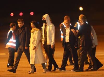 The released hostages make their way across the tarmac. EPA
