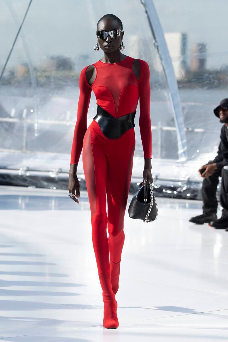 A skintight bodysuit in red intatarsia wool with transparent panels on the thighs.