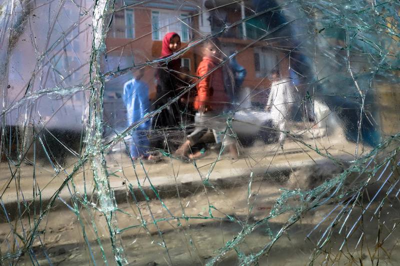 People are seen through a broken car window in the aftermath of a bomb explosion in Kabul, Afghanistan, on 18 March 2021. Hedayatullah Amid / EPA