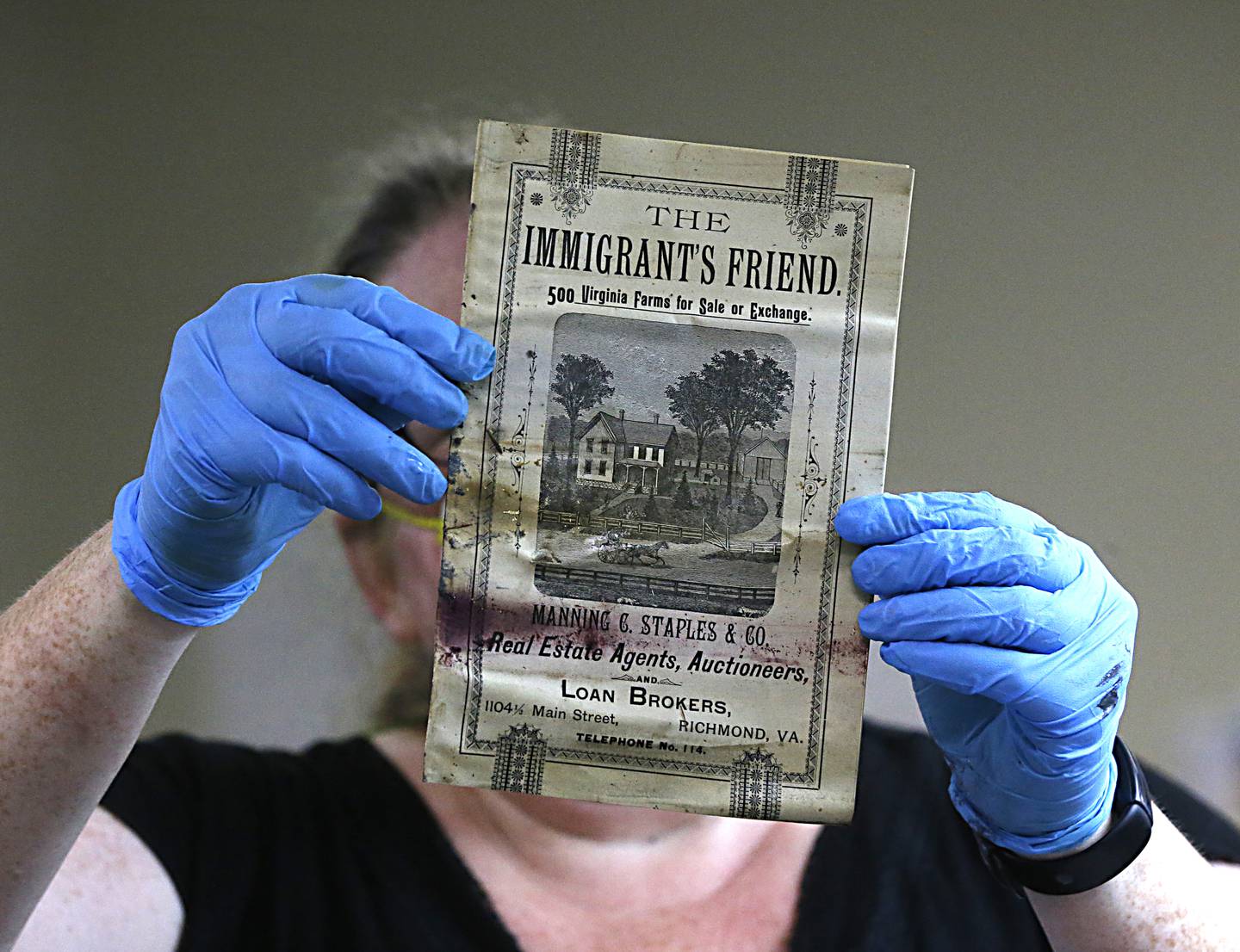Kate Ridgeway holds a pamphlet titled 'The Immigrant's Friend', one of the artefacts inside a copper box time capsule recovered from the base of a Robert E  Lee monument in Richmond, Virginia. Photo via AP,