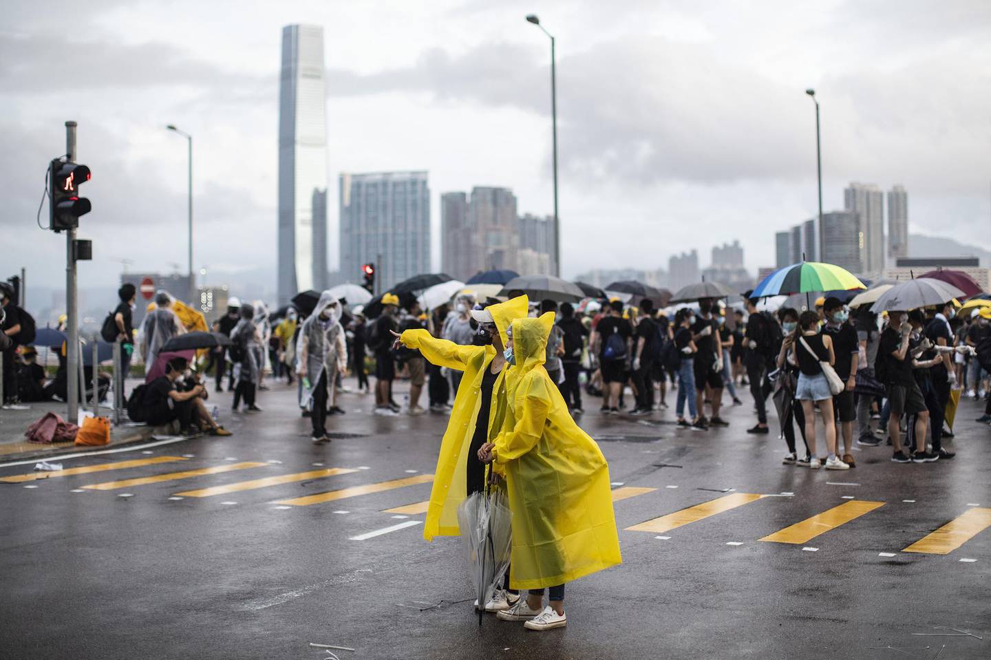 Demonstrators wear yellow raincoats as others gather on Lung Wo Road near the Central Government Complex during a protest in Hong Kong, China, on Monday, July 1, 2019. Hong Kong police clashed with black-clad protesters in a fresh sign of unrest as the city's China-backed chief executive promised to be more open and inclusive at the turbulent start of her third year in office. Photographer: Justin Chin/Bloomberg