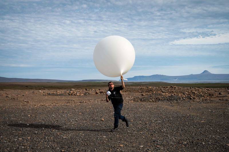 A weather scientist releases a balloon on the Desolation Islands, north of the Antarctic region. AFP
