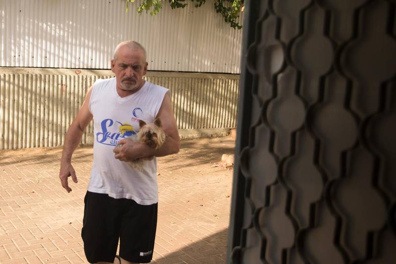 A man carries his dog to safety as he hears sirens warn of incoming rocket strikes from the Gaza Strip on May 17, in Ashdod, Israel. Getty