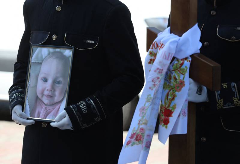 A mourner clutches a picture at the funeral of 3-month-old Kira Glodan. The service was also in memory of her mother and grandmother. All three were among eight people killed in Odesa, Ukraine when a Russian missile hit a residential building. AFP