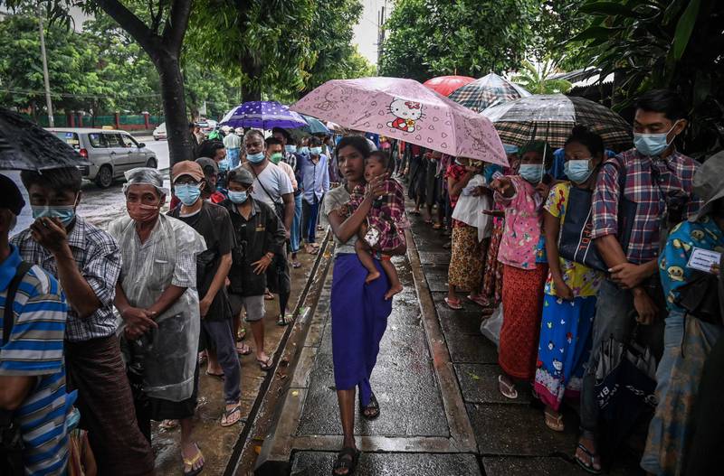 People queue to receive free meal on a street in Yangon, Myanmar. AFP