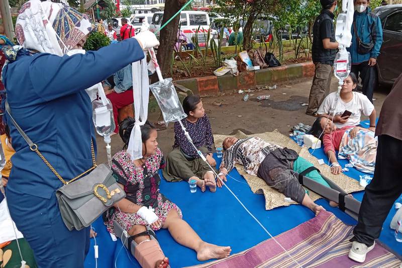 People injured during the earthquake receive treatment at a hospital car park in Cianjur. AP
