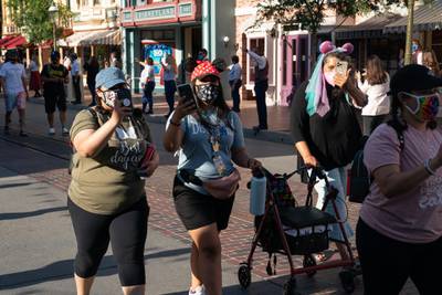 Guests wearing protective masks walk along Main Street USA during the reopening of the Disneyland theme park in Anaheim, California, U.S., on Friday, April 29, 2021. Walt Disney Co.'s original Disneyland resort in California is sold out for weekends through May, an indication of pent-up demand for leisure activities as the pandemic eases in the nation's most-populous state. Photographer: Bing Guan/Bloomberg