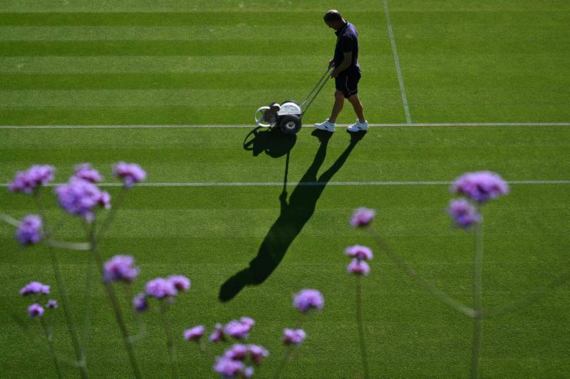 A groundsman cuts the grass on court 18 at the start of the first day of the 2022 Wimbledon Championships in south-west London. AFP