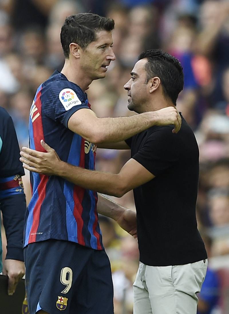 Robert Lewandowski is congratulated by Barcelona coach Xavi as he leaves the pitch. AFP