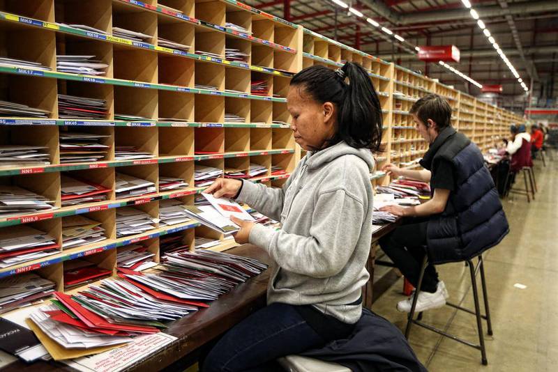 Employees sort through mail on December 17, 2014 in Northampton, England. This week is expected to be the busiest of the year for Royal Mail as they deal with deliveries in the run up to Christmas. Carl Court / Getty Images