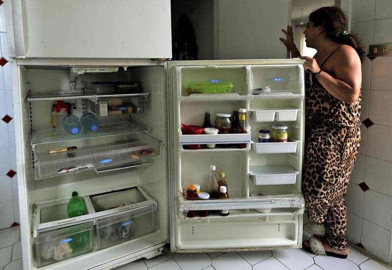 A Lebanese woman displays the content of her refrigerator at her apartment in Jounieh, north of Beirut. AFP