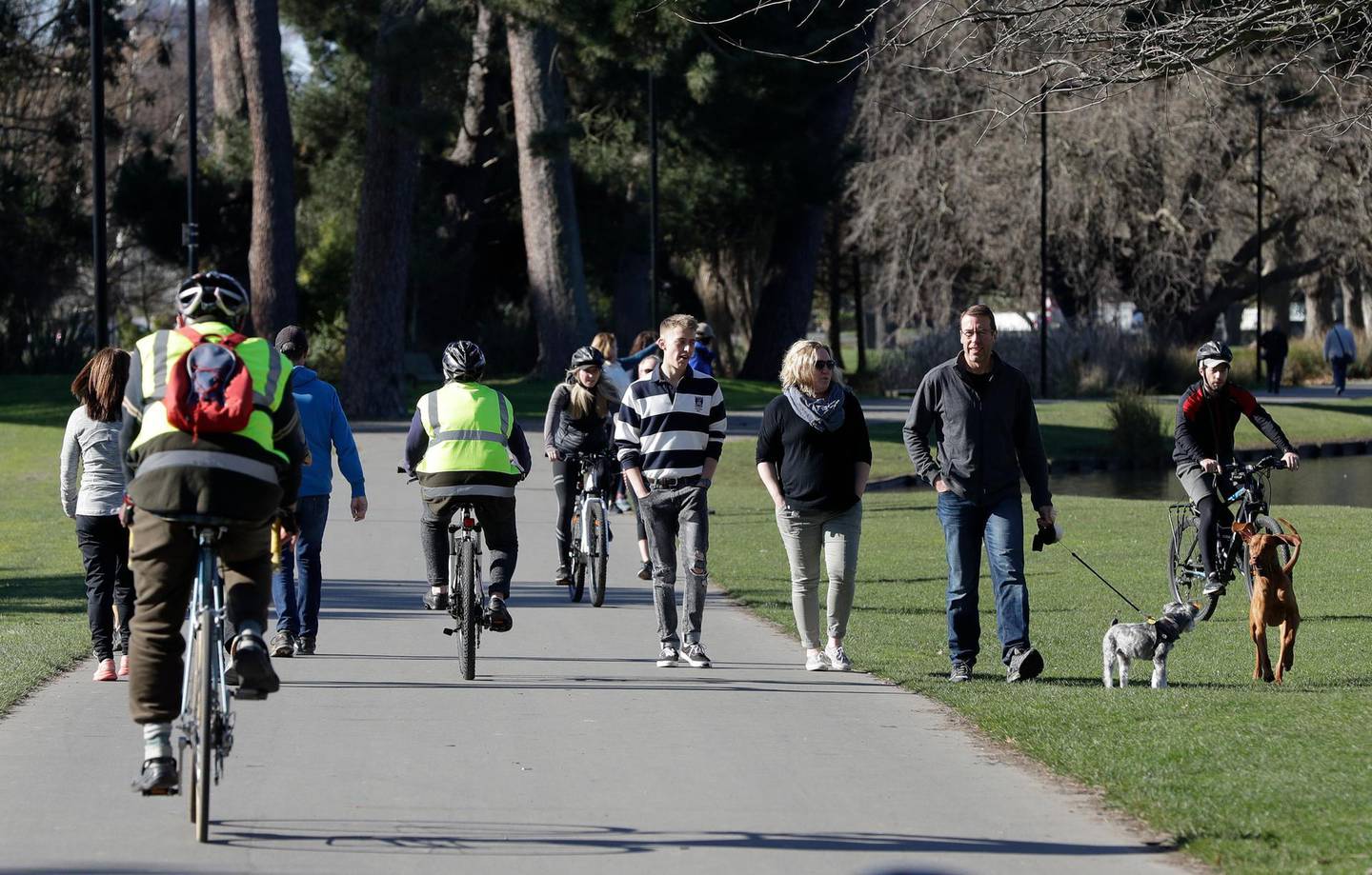 Residents exercise at Hagley Park in Christchurch, New Zealand, Sunday, Aug. 9, 2020. New Zealand on Sunday marked 100 days since it stamped out the spread of the coronavirus, a rare bright spot in a world that continues to be ravaged by the disease. (AP Photo/Mark Baker)