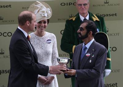 2016 - Sheikh Mohammed bin Rashid is presented with a cup by Prince William, Duke of Cambridge, as Catherine, Duchess of Cambridge, looks on on the second day of the Royal meet. AFP