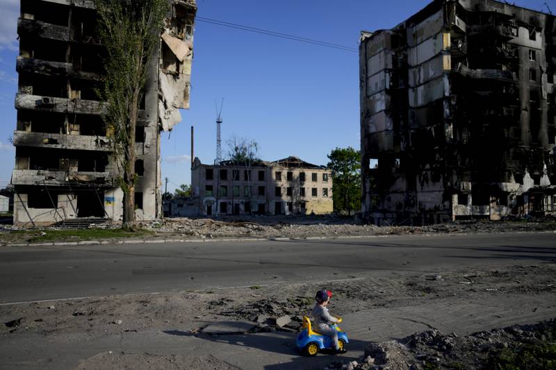 A child plays against a backdrop of buildings ruined by shelling in Borodyanka, Ukraine. AP