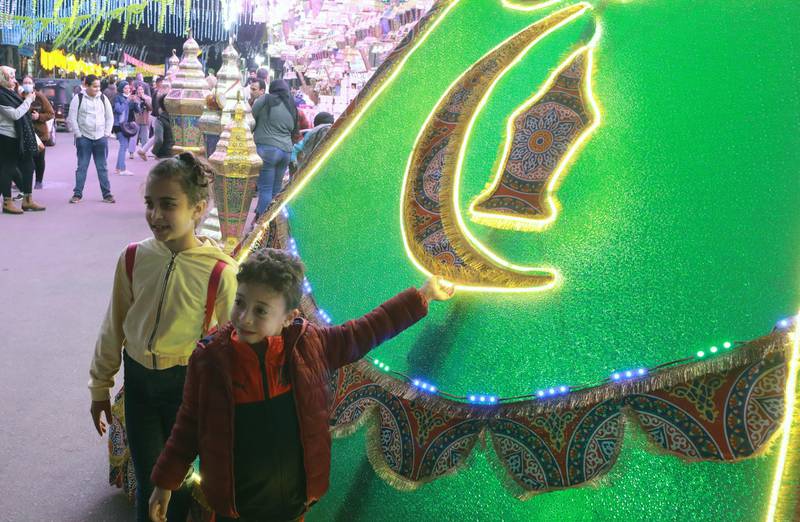 Children pose for a photo with a Ramadan ‘fanous’ (lantern) decoration at a market in Cairo, Egypt, on April 1, 2021. EPA