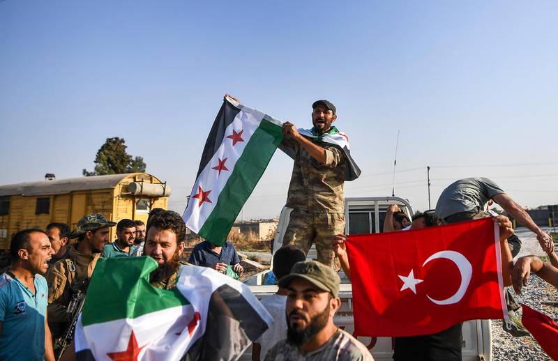 Turkish-backed Syrian opposition fighters celebrate in Akcakale, in Sanliurfa province advance, after entering over the border from Tal Abyad, Syria. AP Photo