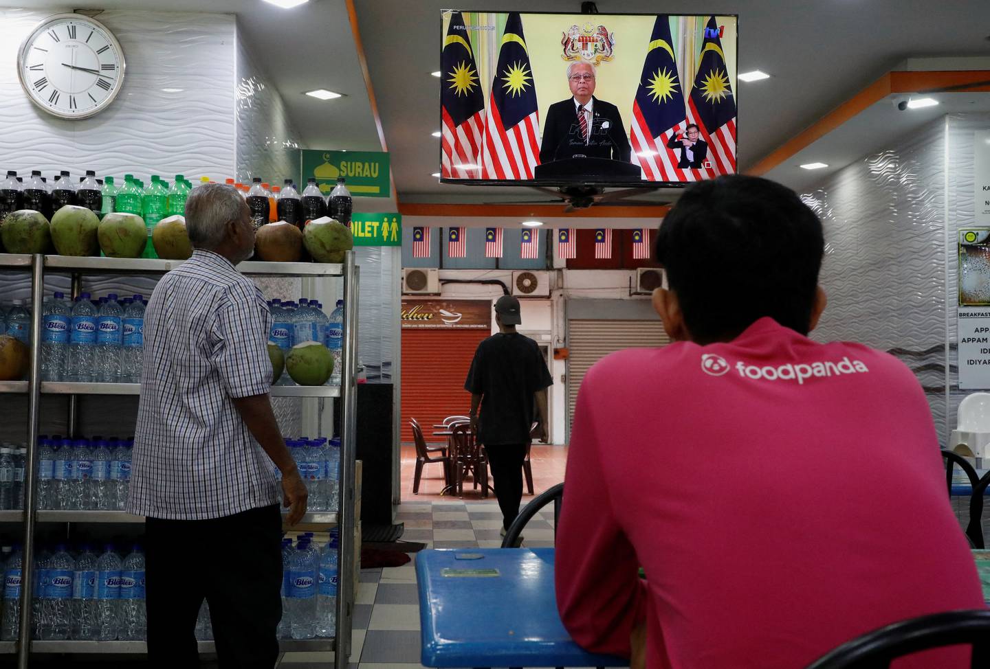 People at a restaurant watch the announcement by Malaysian Prime Minister Ismail Sabri Yaakob dissolving the parliament and calling for general elections, in Kuala Lumpur, on October 10. Reuters