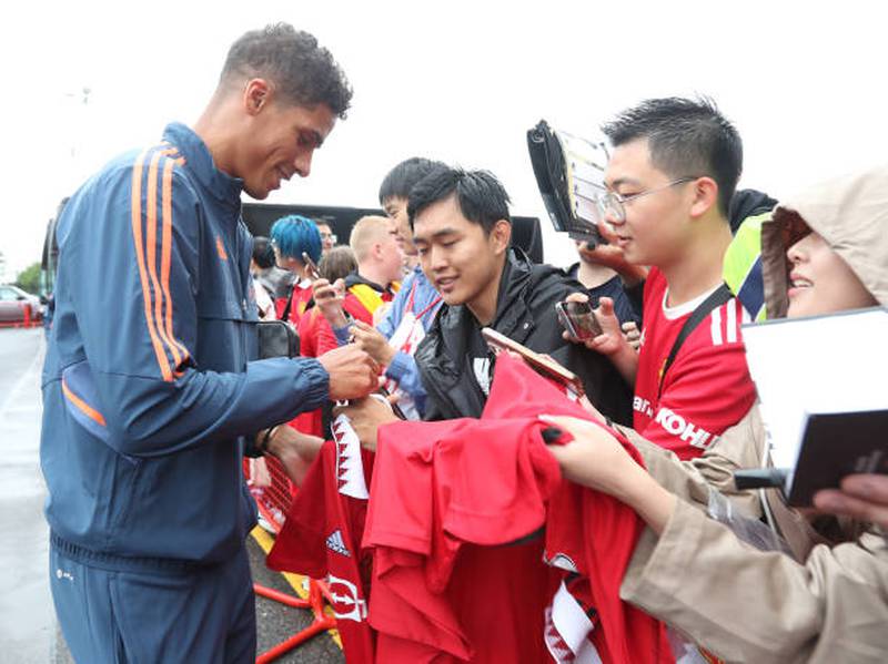Raphael Varane of Manchester United arrives at Old Trafford and signs autographs for fans. Getty