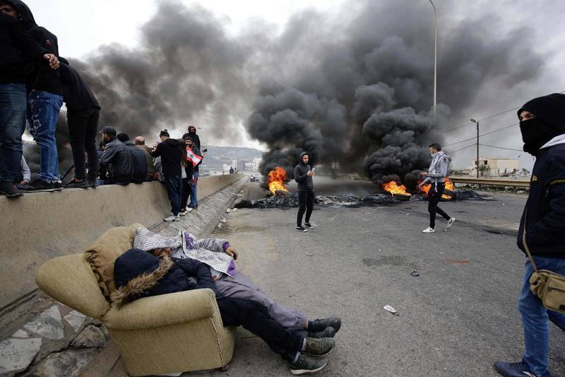 Lebanese anti-government protesters burn tyres as they block the road leading to the southern entrance of the northern port city of Tripoli. AFP