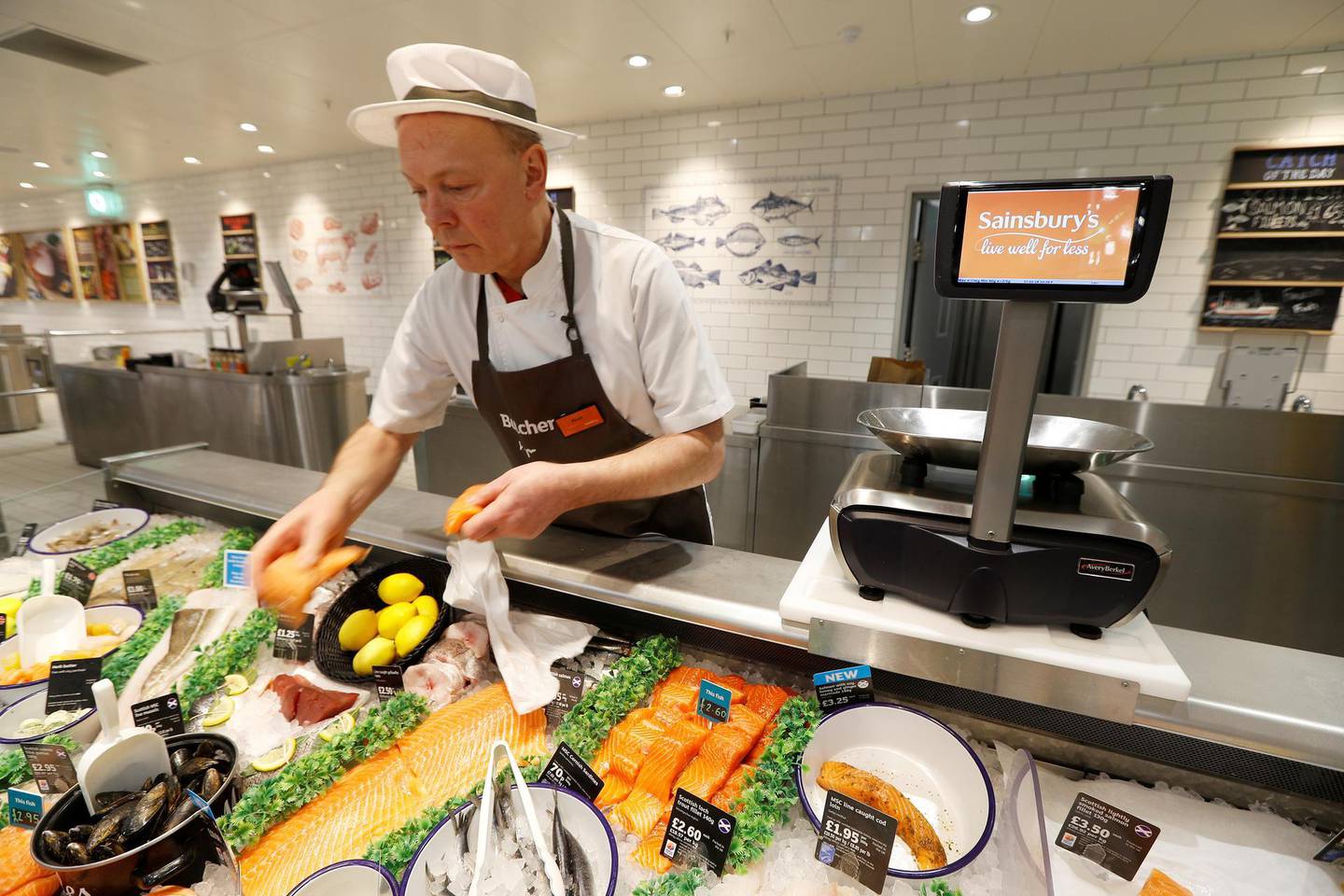 FILE PHOTO: A Sainsbury's worker fills a fish counter in a store in Redhill, Britain, March 27, 2018. REUTERS/Peter Nicholls/File Photo
