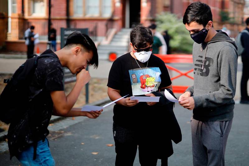 Students at Newham Collegiate Sixth Form react as they receive their A-Level results in east London on August 13, 2020. English authorities reassured school pupils they would be graded fairly for exams missed because of the coronavirus, after the Scottish government was forced into a major U-turn on the issue. / AFP / Tolga Akmen
