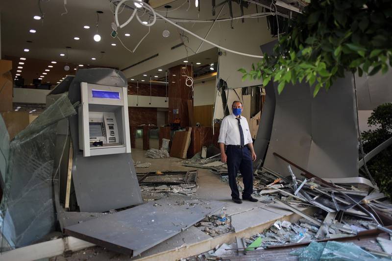 A worker wearing a protective face mask stands at the entrance to a destroyed Fransabank SAL branch in Beirut. Bloomberg